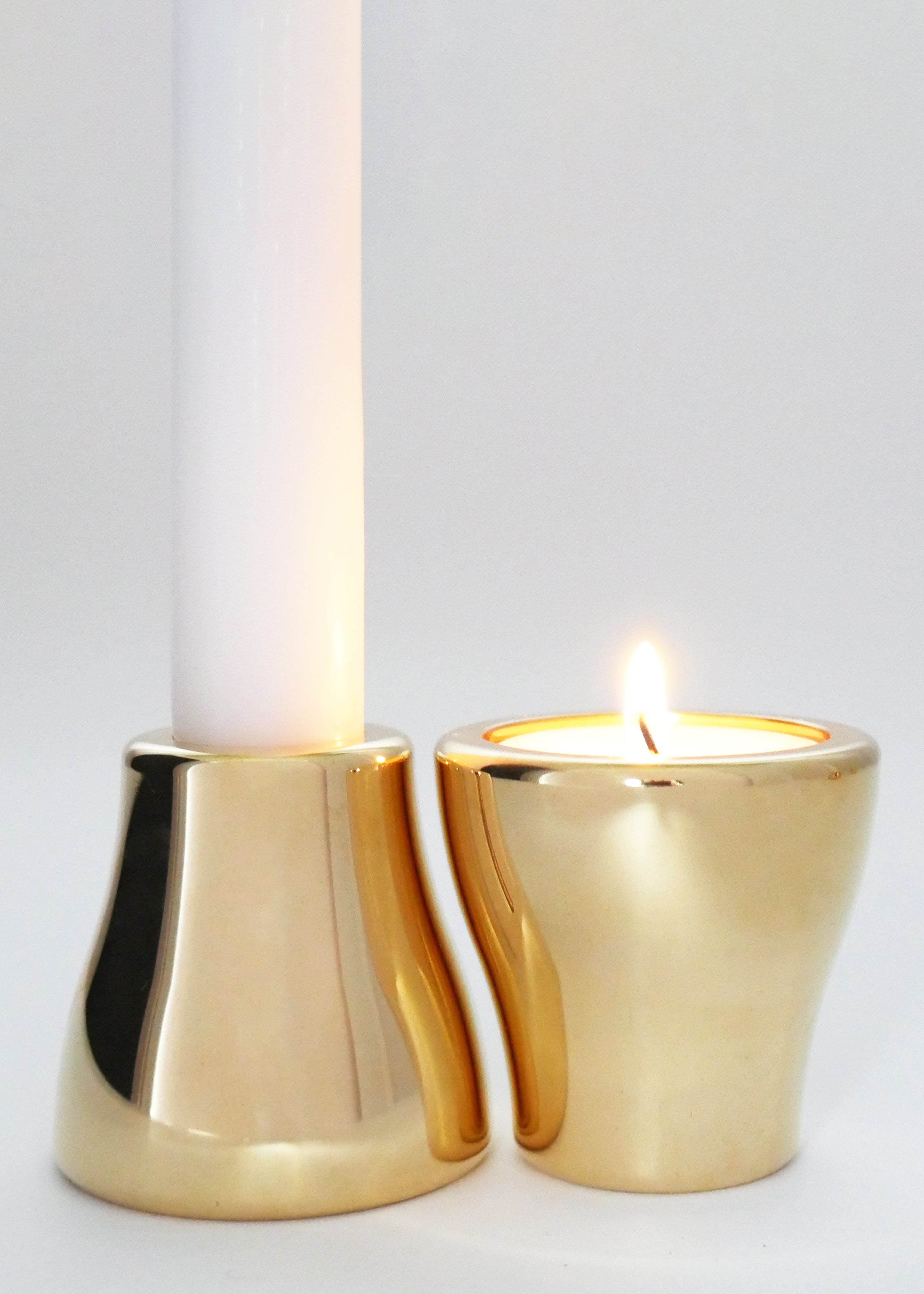 One brass candleholder with taper candle and one brass candleholder with tealight candle